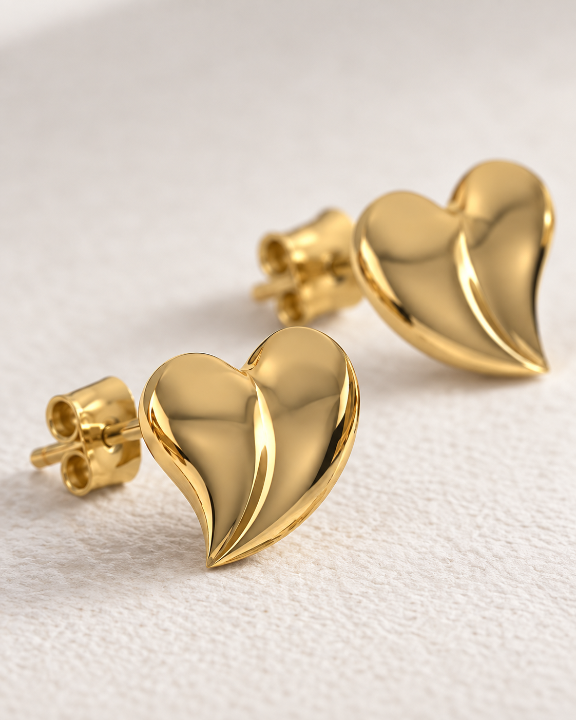 Close-up of Puffed Heart Silver Studs, showing the gold finish over sterling silver