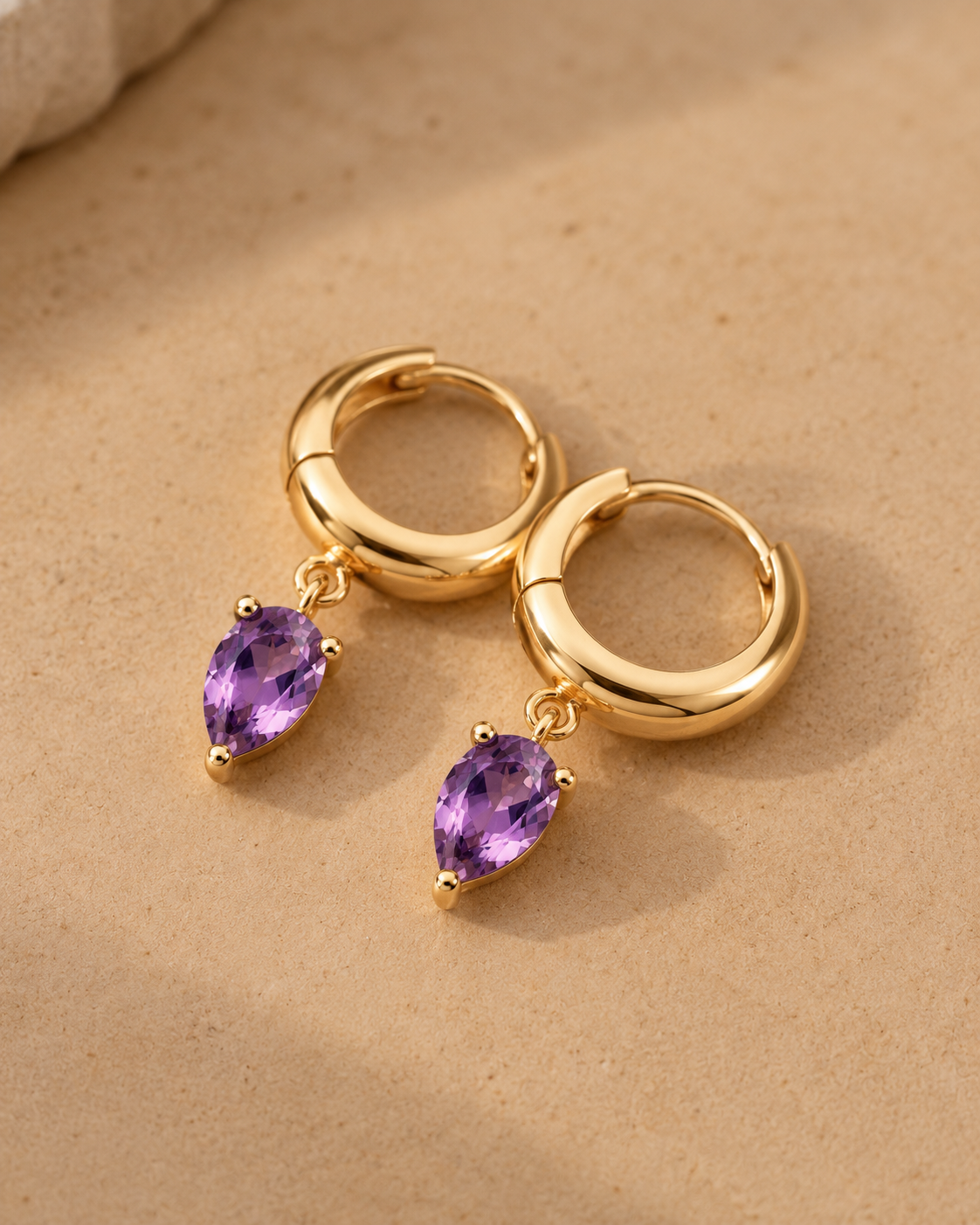 Close-up of Amethyst Pear Drop Charm Hoops, showing the gold finish over sterling silver